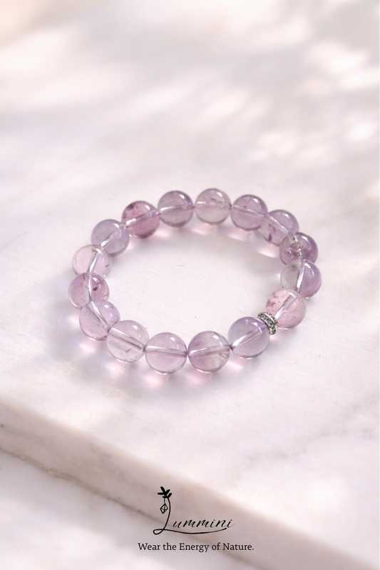 Purple beaded bracelet on a white surface with 'Lumin' brand logo.