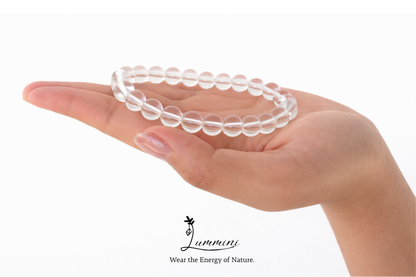 Clear beaded bracelet on a hand with 'Lummini' brand logo.